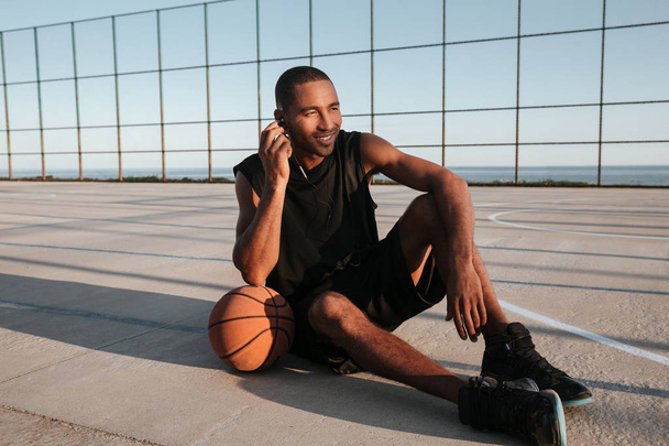Giocatore di basket africano seduto al parco giochi e ascoltare musica
 - Foto, immagini
