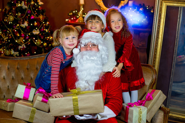 Santa Claus and group of girls with Christmas gifts - Photo, Image