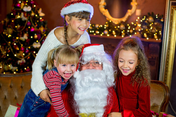 Santa Claus and group of girls with Christmas gifts - Photo, Image