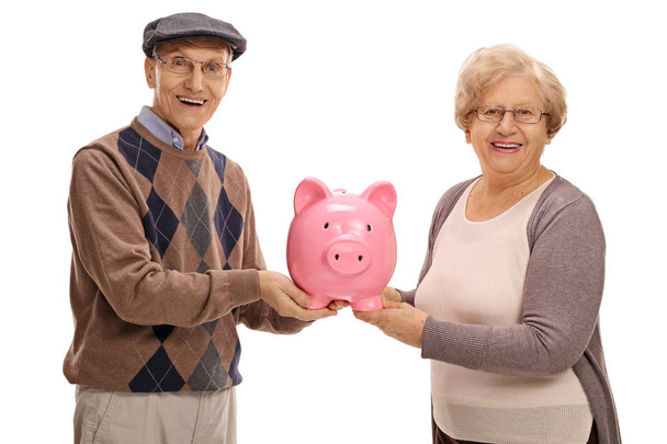 Happy seniors holding a piggybank - Фото, изображение