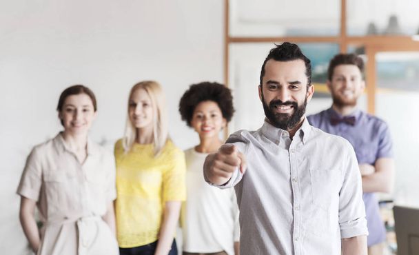 happy man pointing finger at you over office team - Photo, image