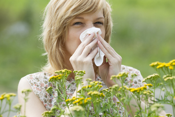 Жінка дме ніс в тканину на відкритому повітрі
 - Фото, зображення