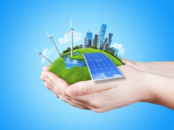 handen houden heldergroene weiland met zon batterijblok, molen windturbines en wolkenkrabbers van de stad - Foto, afbeelding