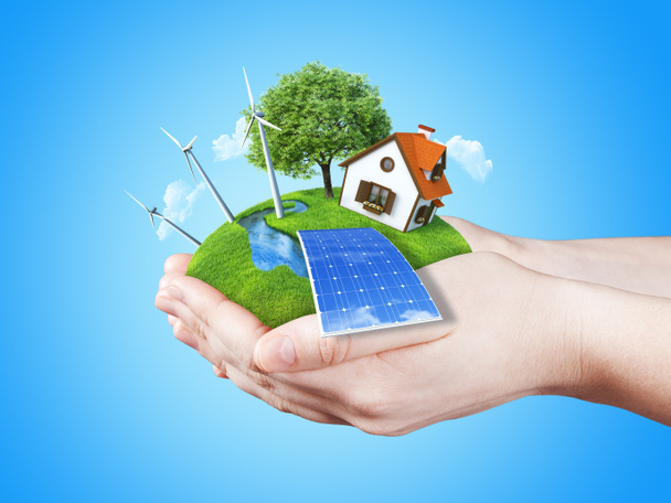 Mains tenant prairie verte claire avec bloc de batterie solaire, éoliennes et maison de campagne
 - Photo, image