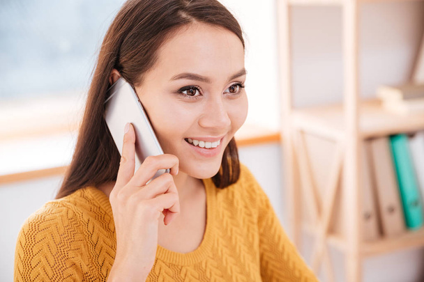 Businesswoman dressed in sweater talking by her phone - Photo, image