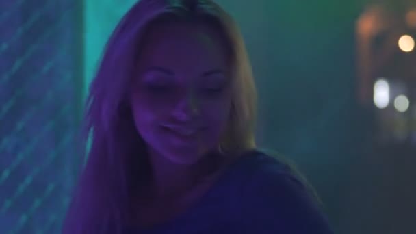 Cheerful young beauty dancing to music, enjoying party atmosphere, strobe lights - Séquence, vidéo
