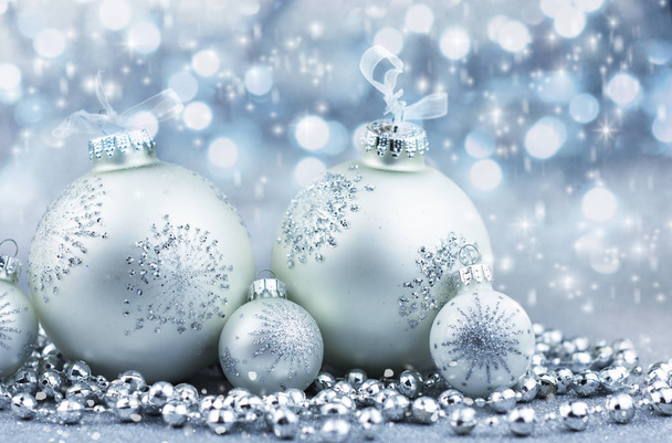 Zilveren kerstballen met decoratie op glanzende achtergrond - Foto, afbeelding