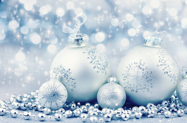 Zilveren kerstballen met decoratie op glanzende achtergrond - Foto, afbeelding