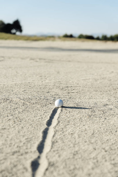 Golf ball in sand bunker - Foto, afbeelding