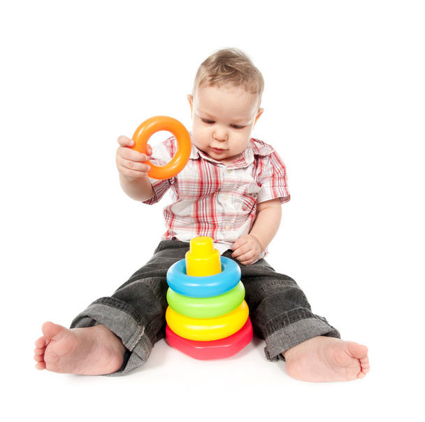 мальчик играет с игрушечной пирамидой изолированы на белом
 - Фото, изображение