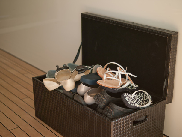 La scatola braun con le scarpe sul pavimento in legno
 - Foto, immagini