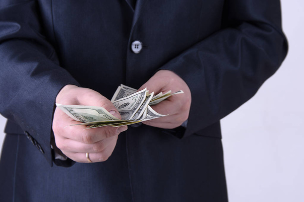 Ένας άντρας σε ένα επαγγελματικό κοστούμι προσφέρει χρήματα - Φωτογραφία, εικόνα