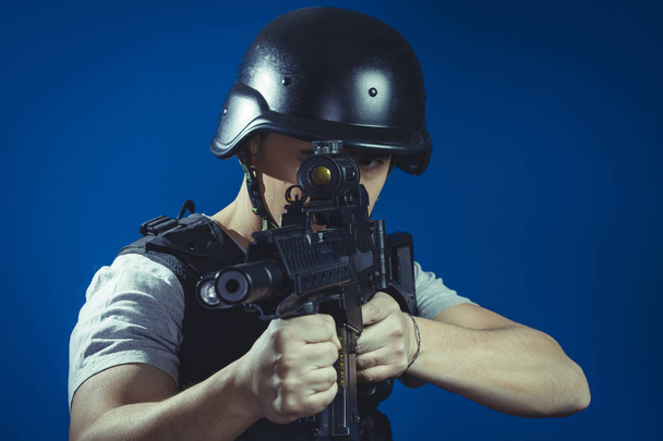 paintball sport player in helmet and machine gun - Photo, image