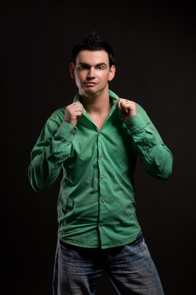 portrait of man in green shirt on black - Photo, Image