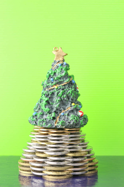 Coins, pyramid, Christmas tree. The new year holiday. Business growth concept Finance. Green background and dark . - Фото, изображение