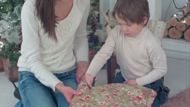 Mother and son cutting wrapping paper for Christmas gifts - 映像、動画