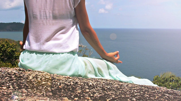 Frau meditiert auf einem hohen Berg vor Meereskulisse - Filmmaterial, Video