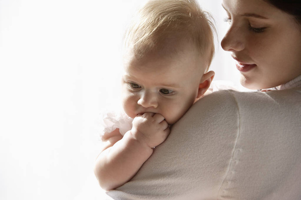 Baby girl over mother's shoulder - Fotografie, Obrázek