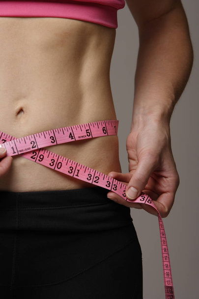 torso of woman measuring her waist - Foto, afbeelding