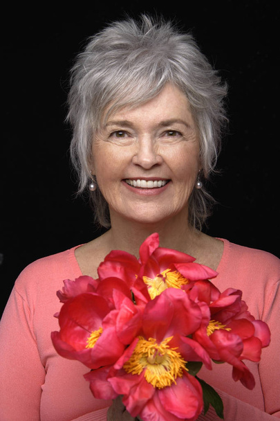woman holding bright pink flowers - Фото, зображення