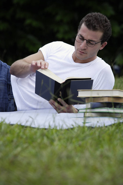 man with books on grass - Zdjęcie, obraz
