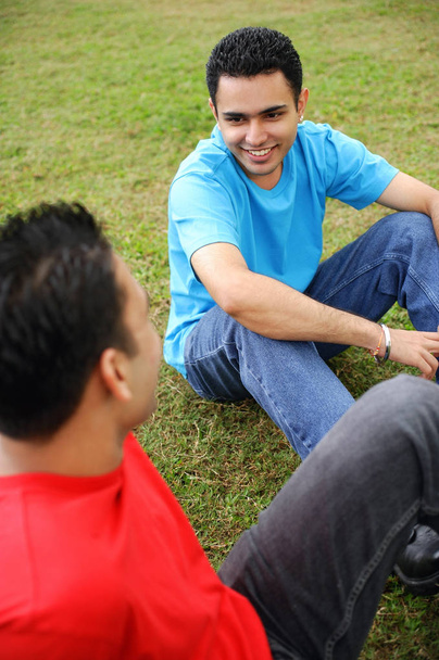 Two men sitting on grass - Foto, Bild