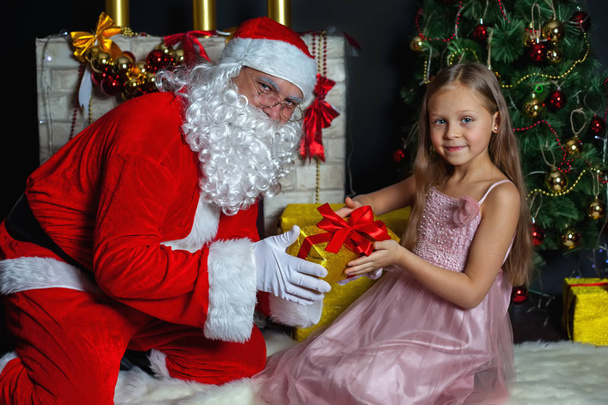 Santa Claus and a girl in a dress. Christmas Scenes. - Fotoğraf, Görsel