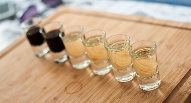 Brandy in shot glasses lined up in a row - Φωτογραφία, εικόνα