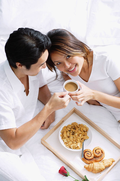 Couple on bed with breakfast tray - Foto, imagen