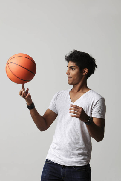 young man twirling basket ball  - 写真・画像
