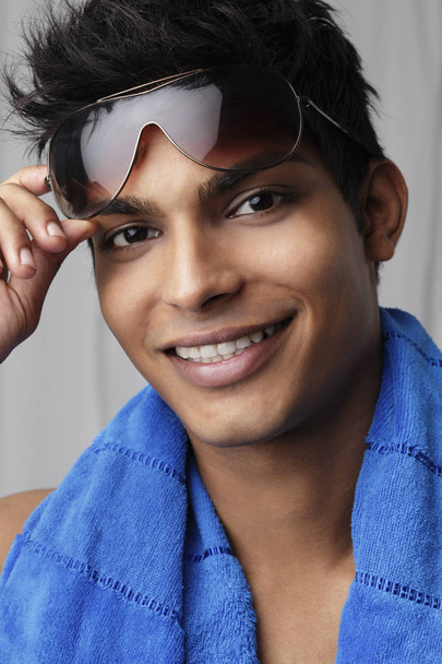 head shot of young man holding sunglasses - Foto, afbeelding