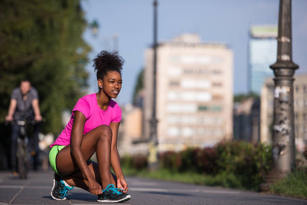 African american woman runner tightening shoe lace - Foto, Imagen
