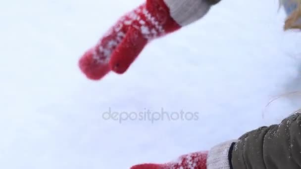 Manos femeninas en manoplas de punto haciendo bola de nieve
 - Imágenes, Vídeo