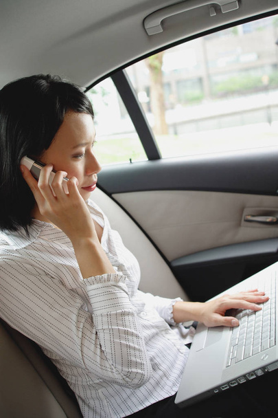 Businesswoman in car with phone  - Zdjęcie, obraz