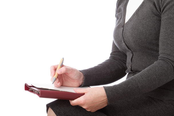 γυναίκα στο γκρι γράφουν από στυλό πάνω σε χαρτί. επιχειρηματίας σημάδια. απομονώνονται σε λευκό φόντο - Φωτογραφία, εικόνα