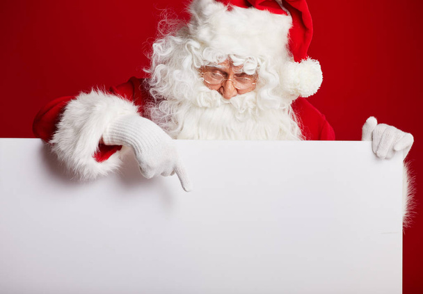 Santa Claus pointing in blank advertisement banner isolated on r - Φωτογραφία, εικόνα