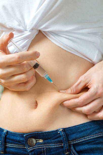 Женщина делает себе инъекцию инсулина
. - Фото, изображение