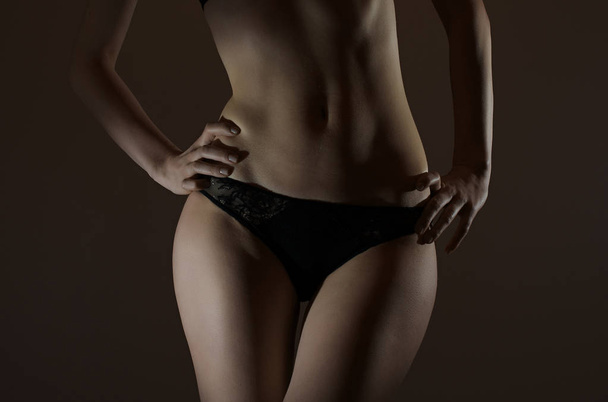 Vista frontal del delgado cuerpo femenino en bragas negras
. - Foto, imagen