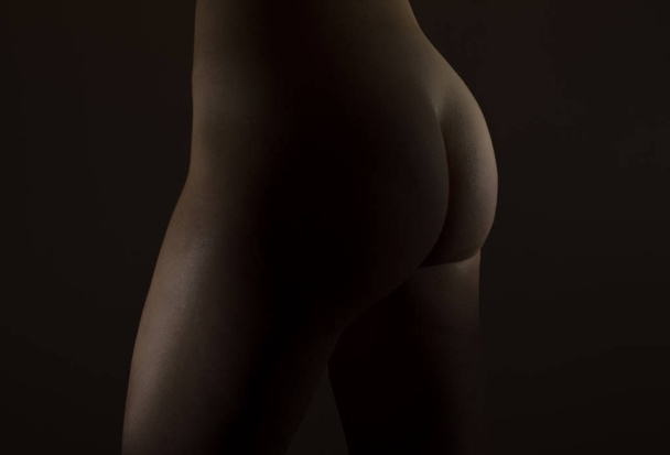 Sexy woman butt on black background. - Photo, Image
