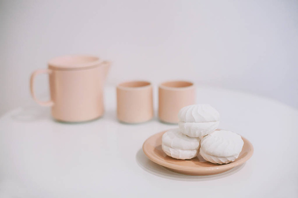 rózsaszín teáskanna és bögrék és mályvacukrot - Fotó, kép