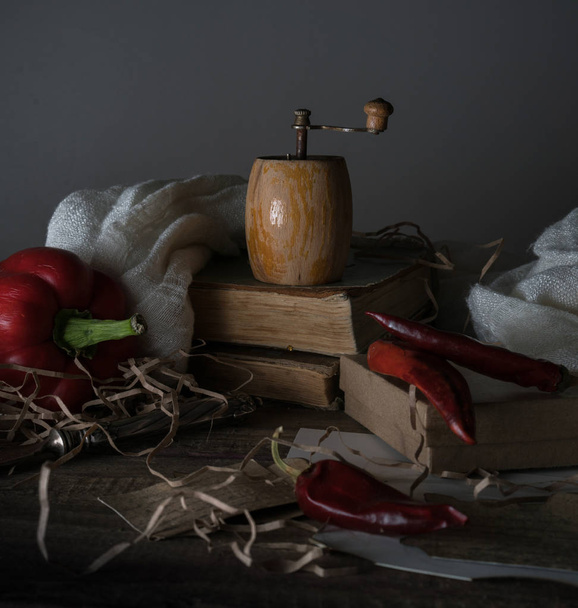 still life, vintage. red pepper, mill, and a towel on  wooden table. - Fotó, kép