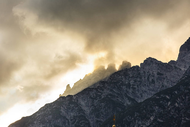 Montañas picos de piedra con nubes naranjas bajo la luz del atardecer
. - Foto, imagen