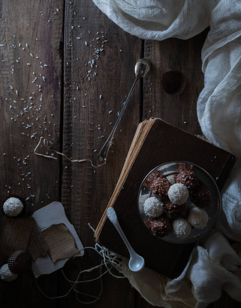 still life, vintage. candy, drapery, old books and a letter on  wooden table. black background, top view - Foto, immagini