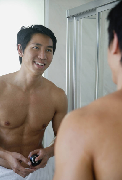 Man in bathroom, looking at mirror - Valokuva, kuva