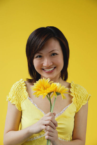 Woman holding yellow flowers - Foto, Bild