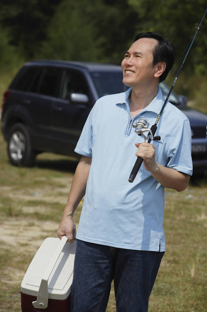 man holding fishing pole and cooler - Fotografie, Obrázek