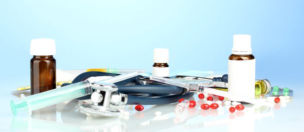 medicines and a stethoscope on a blue background close-up - Valokuva, kuva