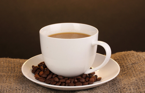 Cup of coffee on sacking on brown background - Photo, Image