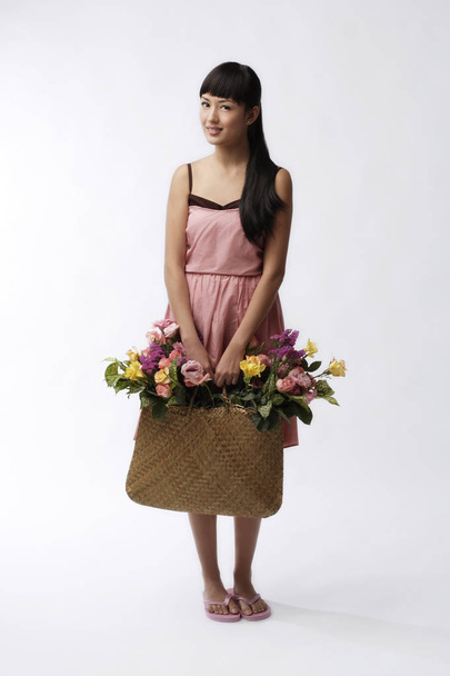 Young woman holding straw bag - Foto, imagen