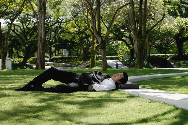 A man lies down in the park - Foto, afbeelding